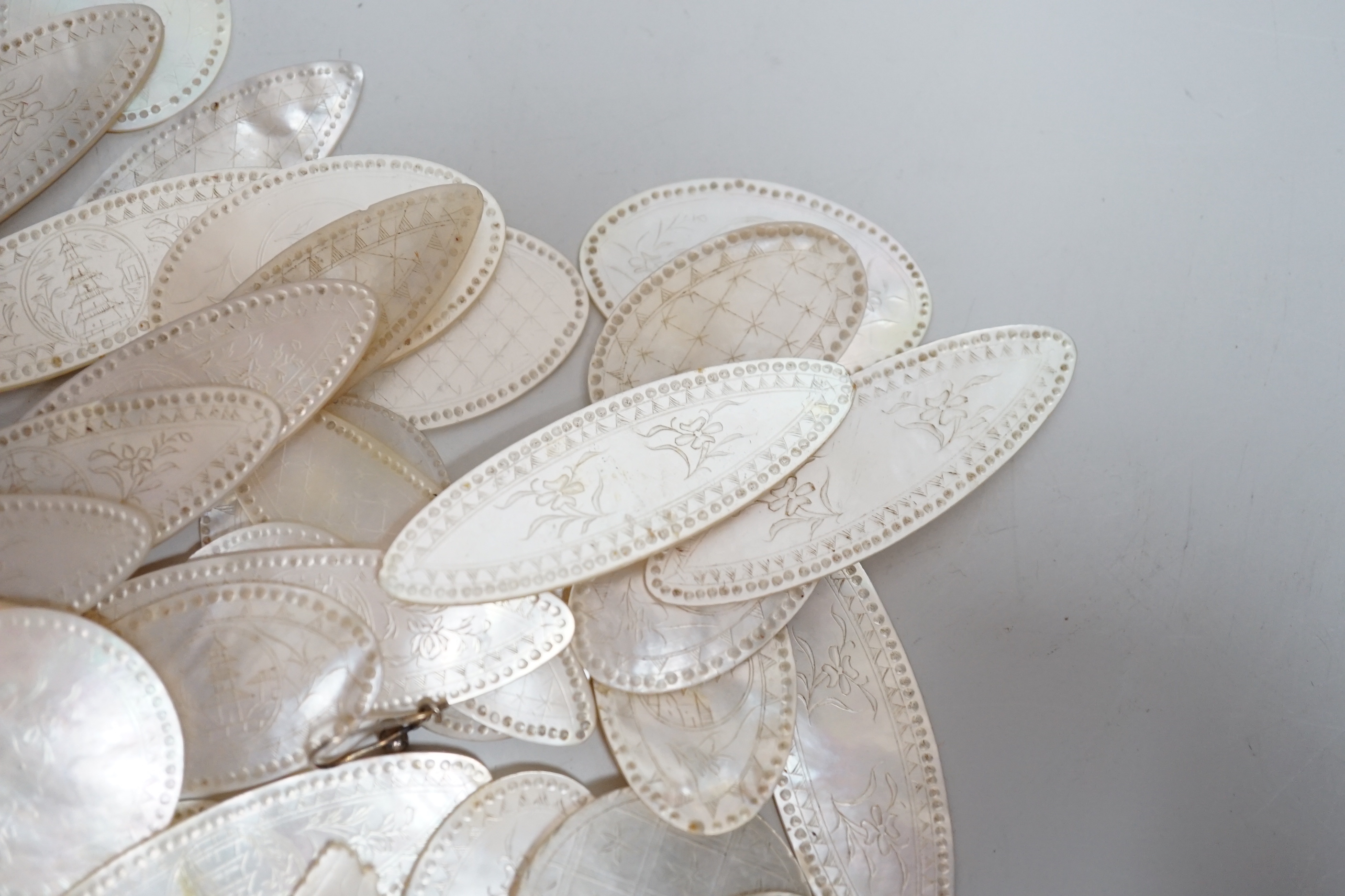 A collection of Chinese mother of pearl counters or tokens including two converted to drop earrings, the largest 5cm wide